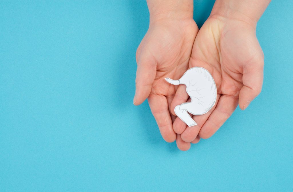 Holding a stomach in the hand, inflammation digestive system, gastrointestinal health issues
